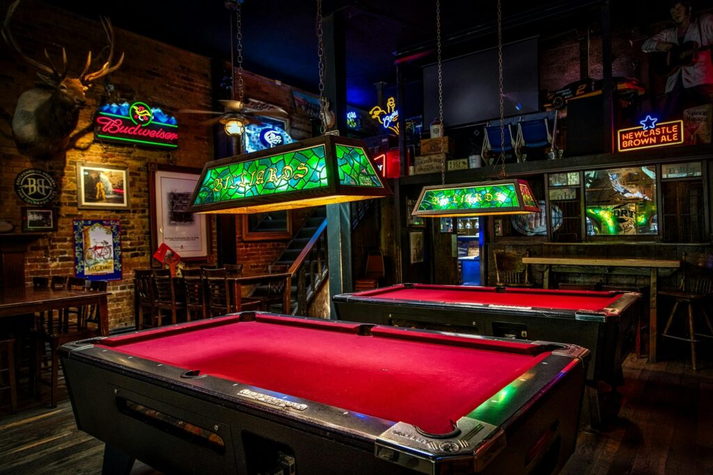 Brown and Red Billiards Tables With Green Lamps